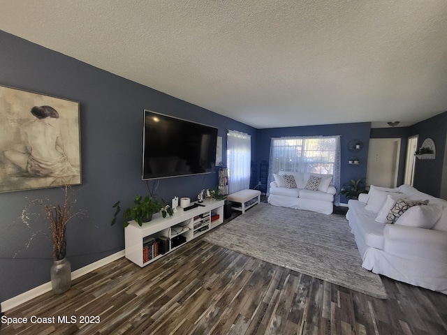 living room with dark hardwood / wood-style floors and a textured ceiling