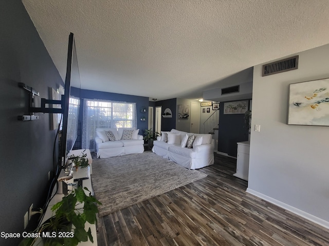 unfurnished living room with dark wood-type flooring and a textured ceiling