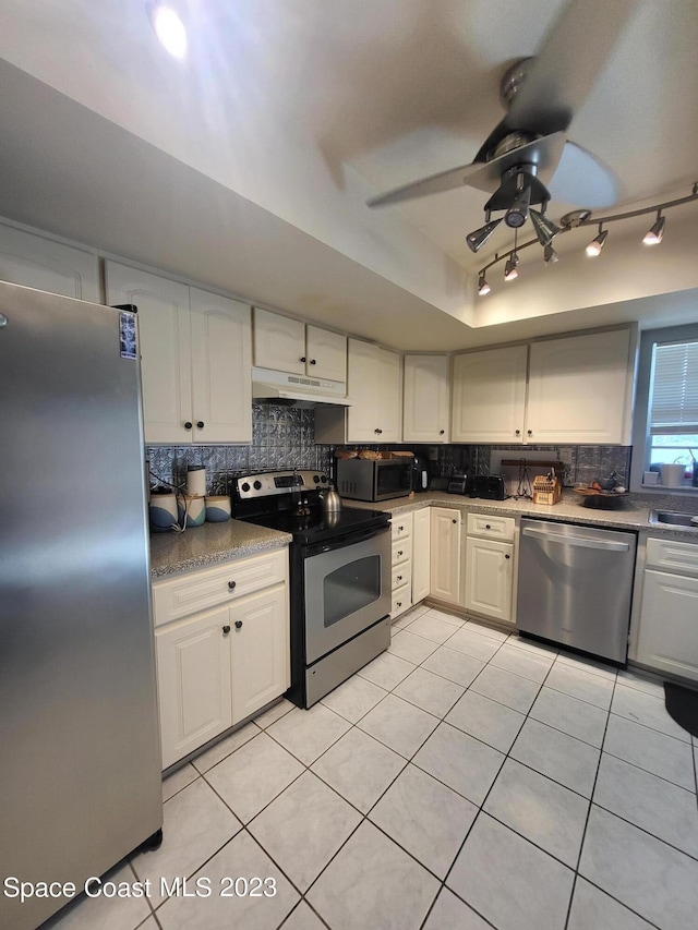 kitchen featuring light tile patterned flooring, ceiling fan, stainless steel appliances, decorative backsplash, and white cabinets