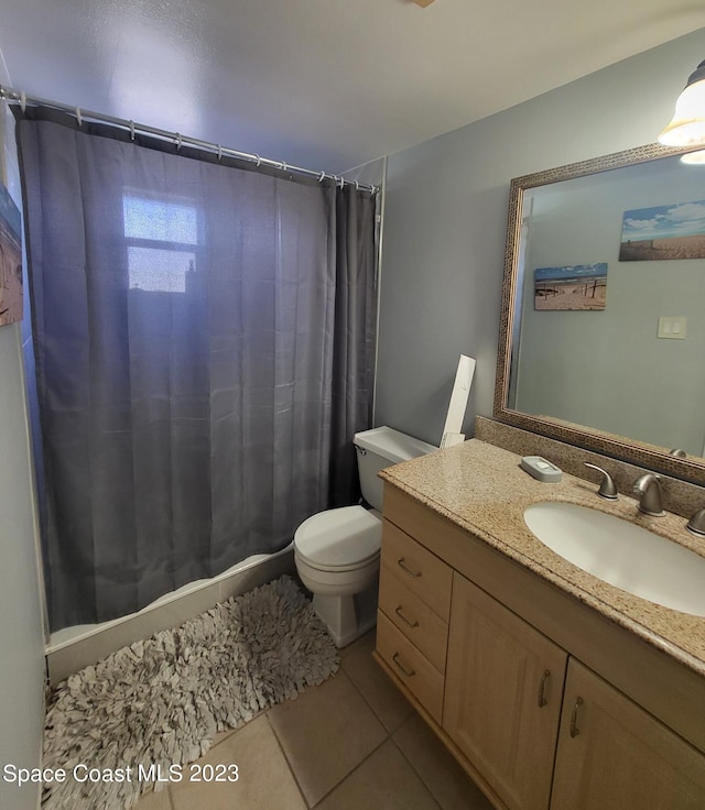 bathroom featuring tile patterned flooring, vanity, and toilet