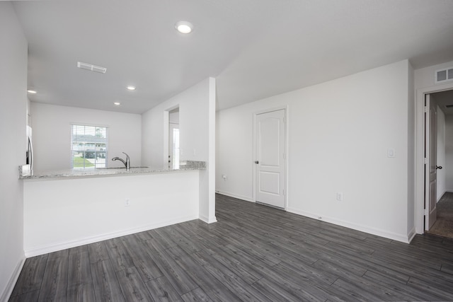 kitchen featuring sink, stainless steel fridge, white cabinets, dark hardwood / wood-style flooring, and kitchen peninsula