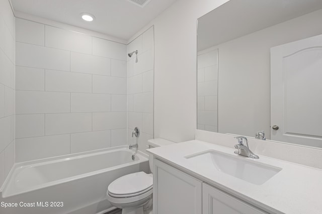 full bathroom featuring large vanity, toilet, and tiled shower / bath combo