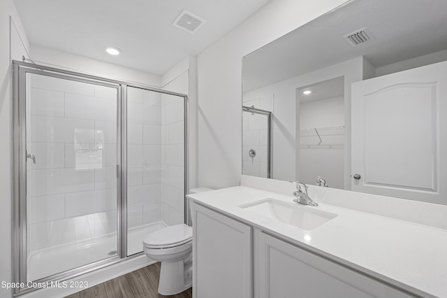 bathroom featuring large vanity, an enclosed shower, wood-type flooring, and toilet