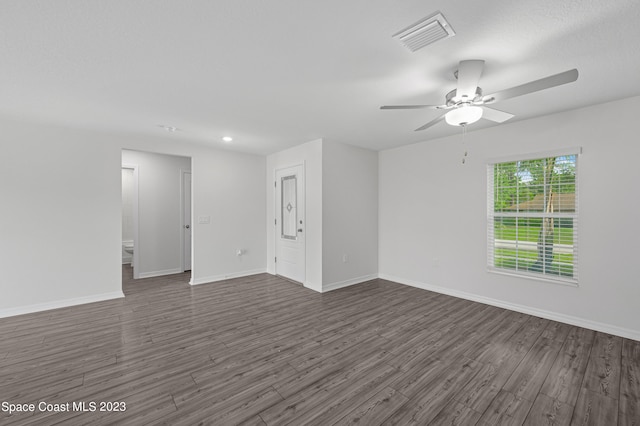 empty room with ceiling fan and dark hardwood / wood-style flooring