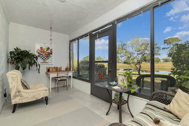 sunroom featuring a water view