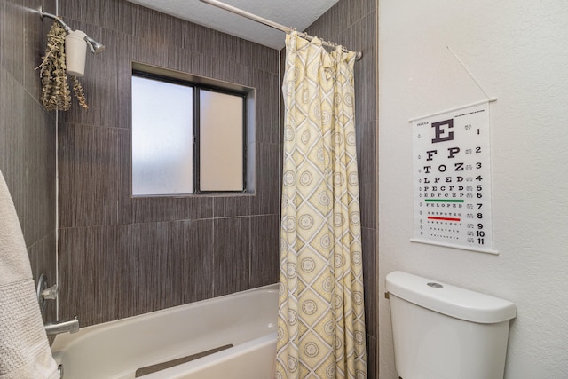 bathroom with shower / bath combination with curtain, a textured ceiling, and toilet