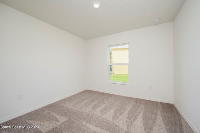 empty room featuring a textured ceiling and carpet