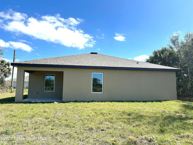 back of house featuring a lawn and a patio area