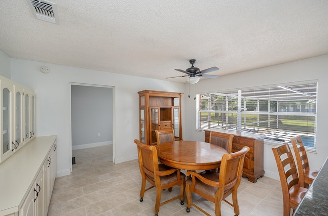 dining room with ceiling fan, a textured ceiling, and light tile flooring