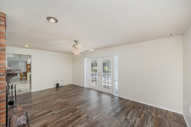 empty room featuring ceiling fan, french doors, a textured ceiling, and dark hardwood / wood-style flooring