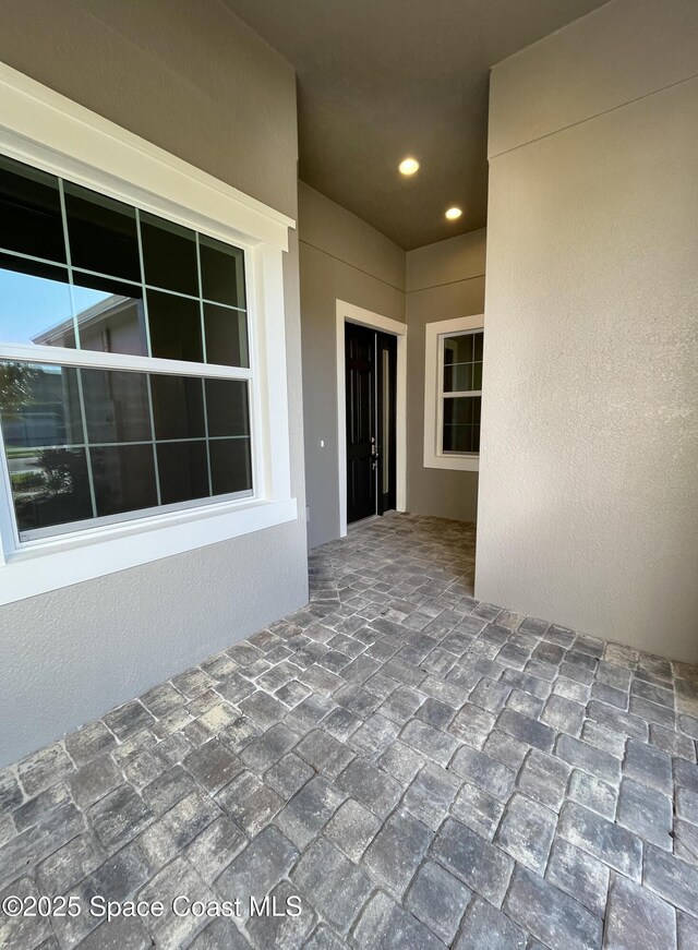 property entrance featuring a patio and stucco siding