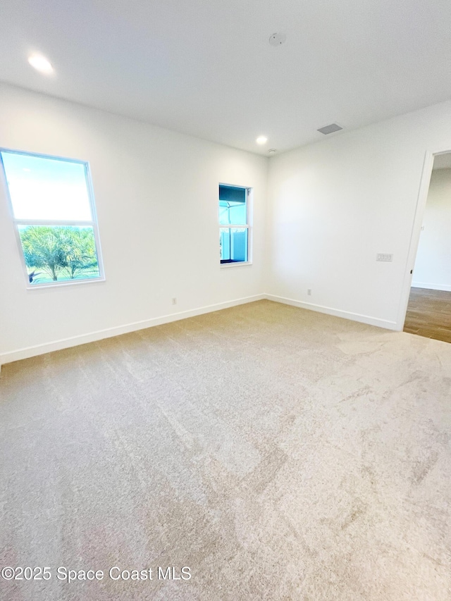 carpeted empty room with recessed lighting, visible vents, plenty of natural light, and baseboards