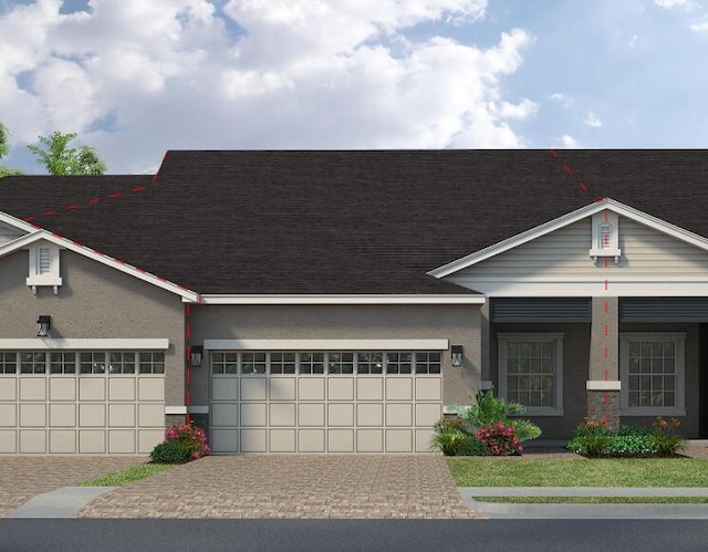 view of front of house featuring stucco siding, decorative driveway, an attached garage, and a shingled roof