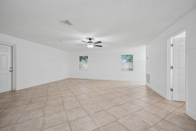 tiled spare room featuring ceiling fan and a textured ceiling