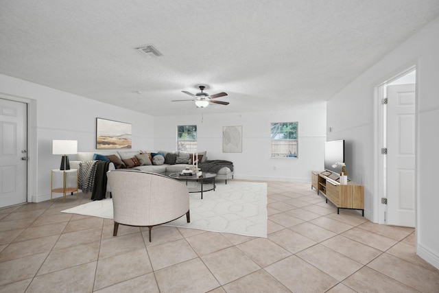 tiled living room with a textured ceiling and ceiling fan