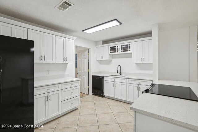 kitchen featuring sink, black appliances, white cabinetry, and light tile patterned flooring