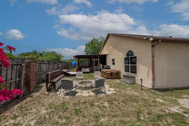 view of yard featuring a wooden deck, a hot tub, and a fire pit