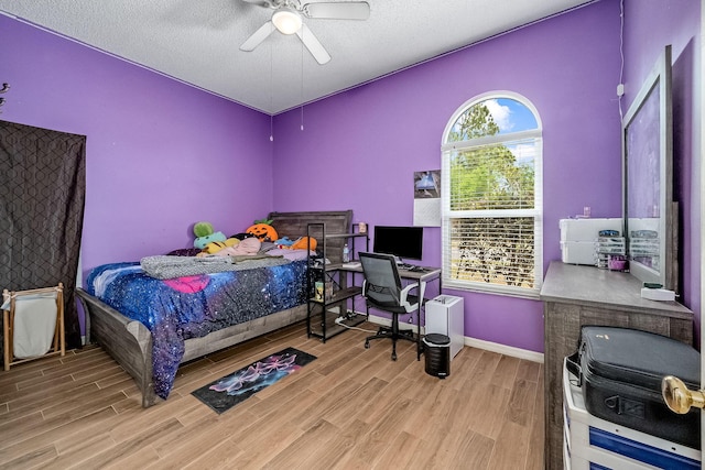 bedroom featuring hardwood / wood-style flooring, ceiling fan, and a textured ceiling