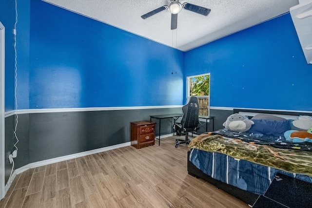 bedroom featuring ceiling fan, wood-type flooring, and a textured ceiling