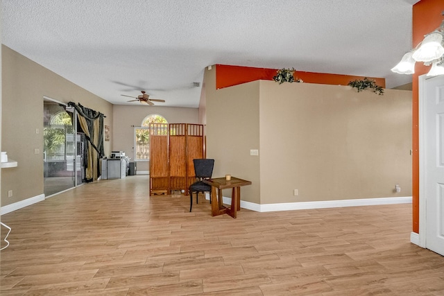 interior space with ceiling fan, light hardwood / wood-style floors, and a textured ceiling