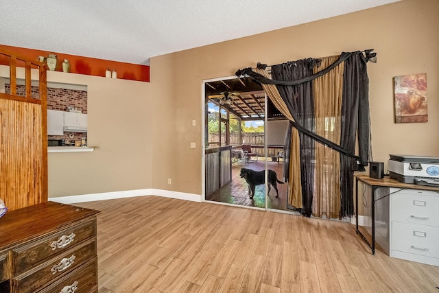 interior space with a textured ceiling and light hardwood / wood-style flooring