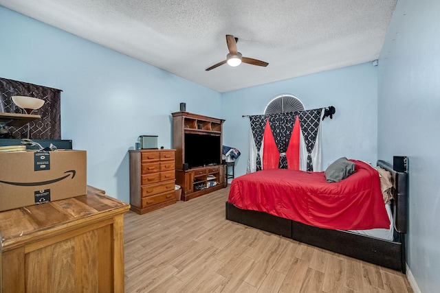 bedroom with ceiling fan, a textured ceiling, and light wood-type flooring