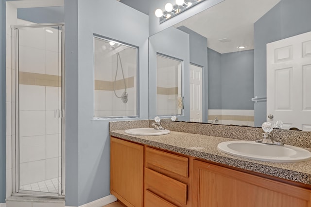 bathroom featuring dual vanity and an enclosed shower