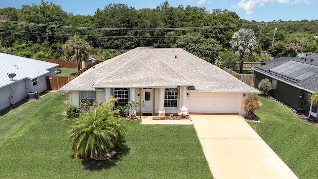 view of front of house featuring central AC unit, a garage, and a front yard