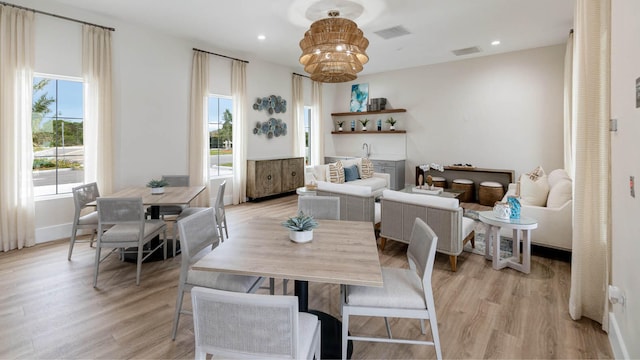 dining room featuring plenty of natural light, an inviting chandelier, and light hardwood / wood-style flooring