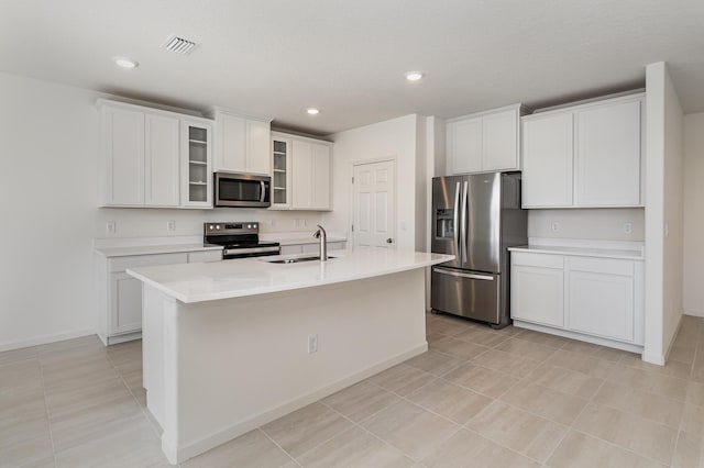 kitchen featuring a center island with sink, white cabinets, and stainless steel appliances