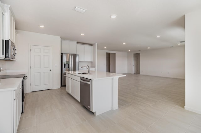 kitchen featuring sink, light tile patterned flooring, a center island with sink, white cabinets, and appliances with stainless steel finishes