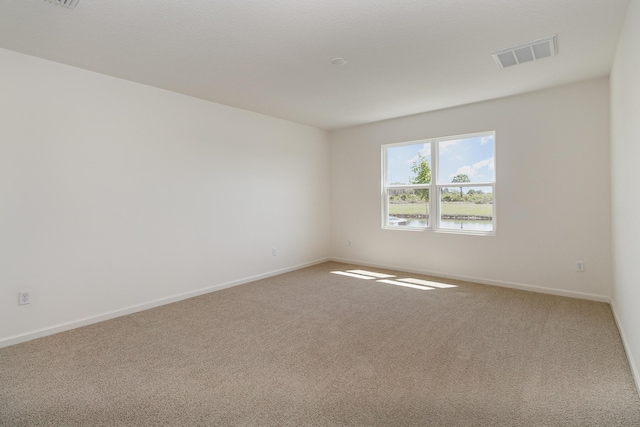 spare room featuring carpet and a water view