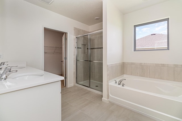 bathroom with vanity, a textured ceiling, independent shower and bath, and tile patterned flooring