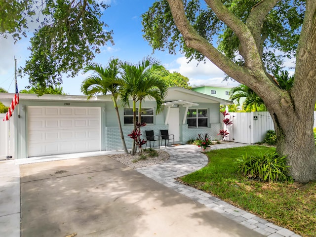 280 Monroe Ave, Cape Canaveral, FL 32920 - view of front of house with brick siding, driveway, an attached garage, and a gate
