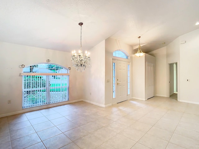 unfurnished room featuring a notable chandelier, vaulted ceiling, and light tile patterned floors