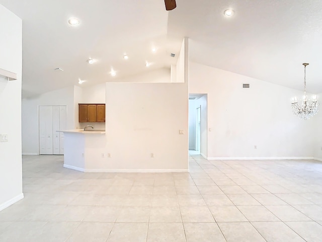 unfurnished living room with high vaulted ceiling, a chandelier, and light tile patterned flooring