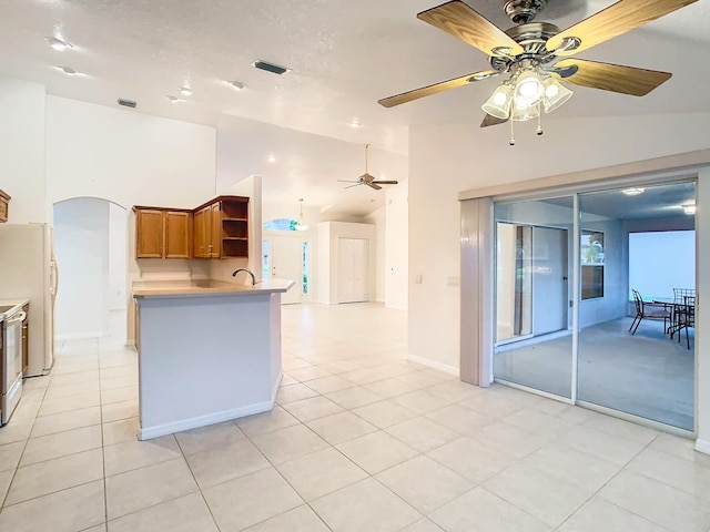 kitchen featuring high vaulted ceiling, light tile patterned floors, ceiling fan, kitchen peninsula, and white appliances