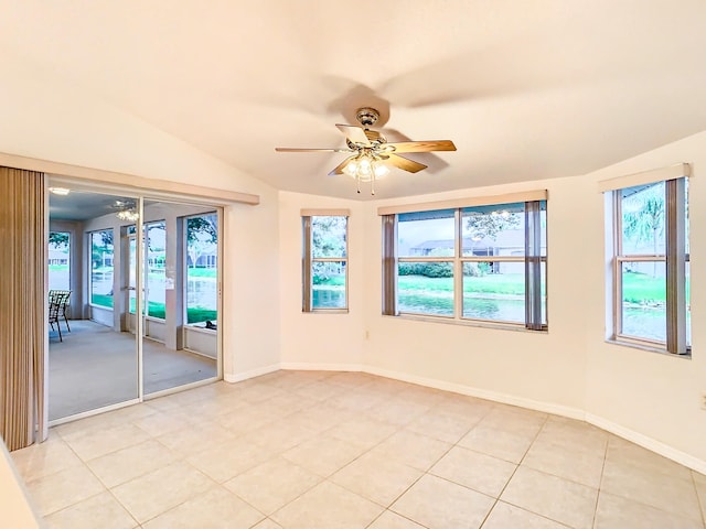 empty room with light tile patterned flooring, ceiling fan, and vaulted ceiling