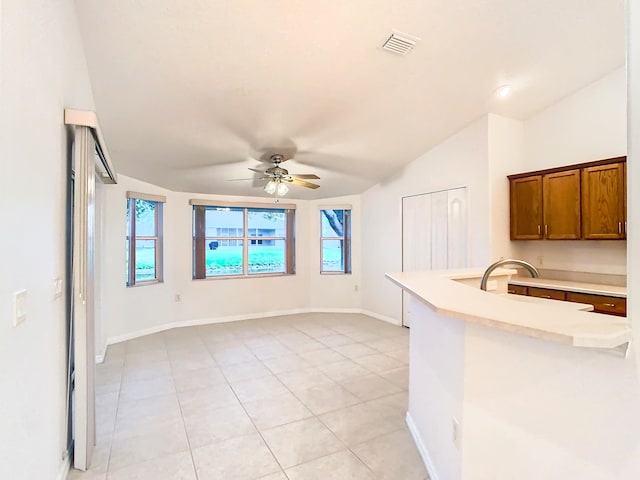 kitchen featuring vaulted ceiling, light tile patterned floors, ceiling fan, and kitchen peninsula