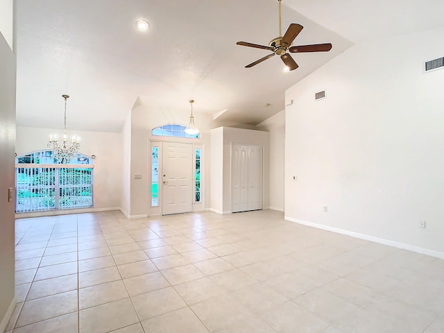 foyer featuring ceiling fan with notable chandelier, vaulted ceiling, and light tile patterned flooring