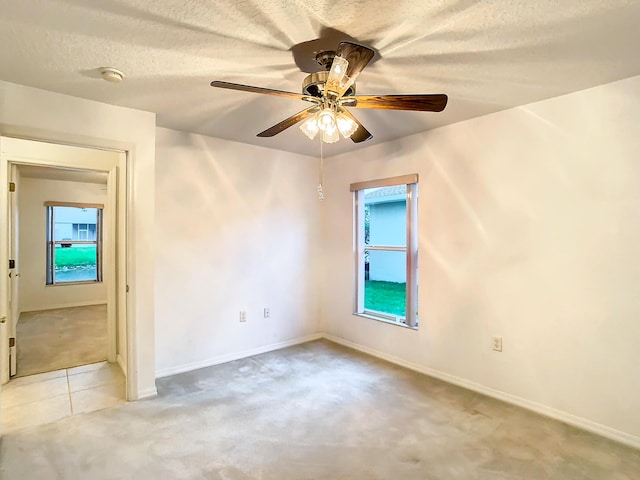 carpeted spare room featuring ceiling fan and a textured ceiling