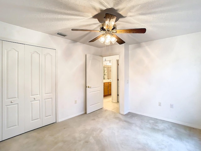 unfurnished bedroom with a textured ceiling, ceiling fan, and a closet