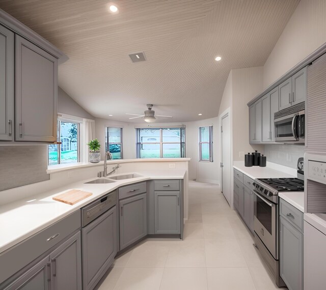 kitchen with appliances with stainless steel finishes, sink, and gray cabinetry