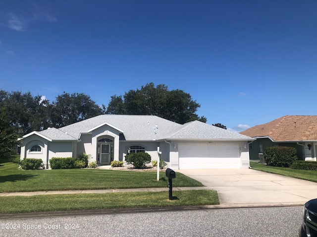 single story home with a garage and a front lawn