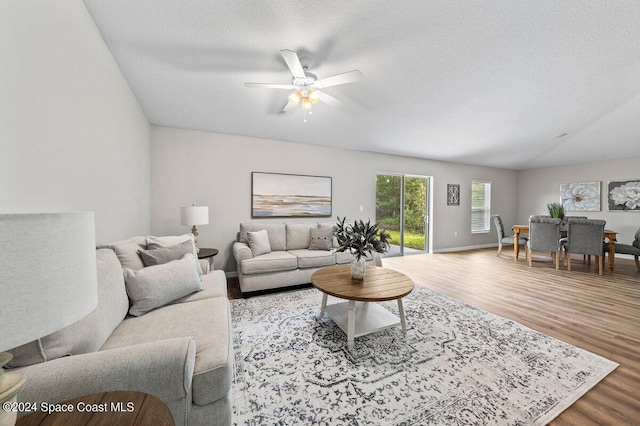 living room with ceiling fan, hardwood / wood-style flooring, and a textured ceiling