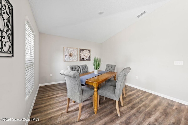 dining area with lofted ceiling and dark hardwood / wood-style floors