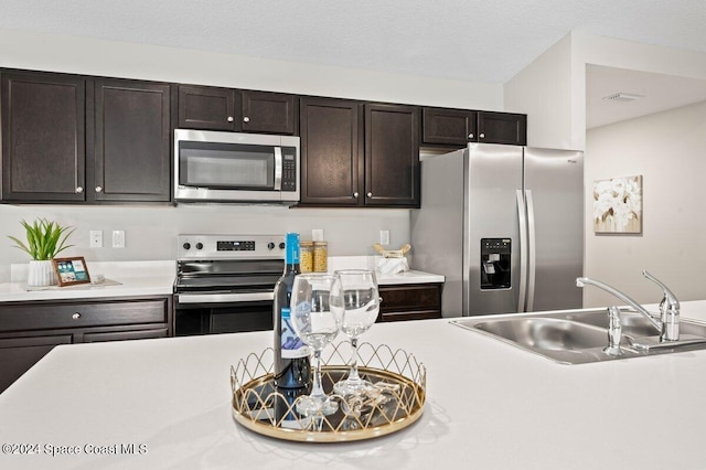 kitchen featuring dark brown cabinets, appliances with stainless steel finishes, and sink