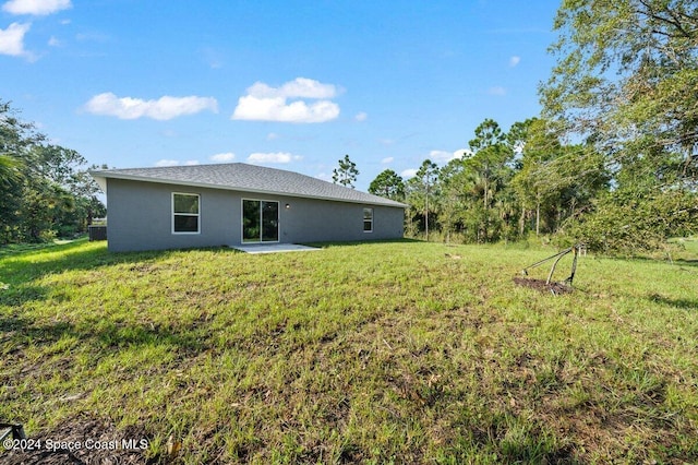 rear view of house featuring a patio and a lawn