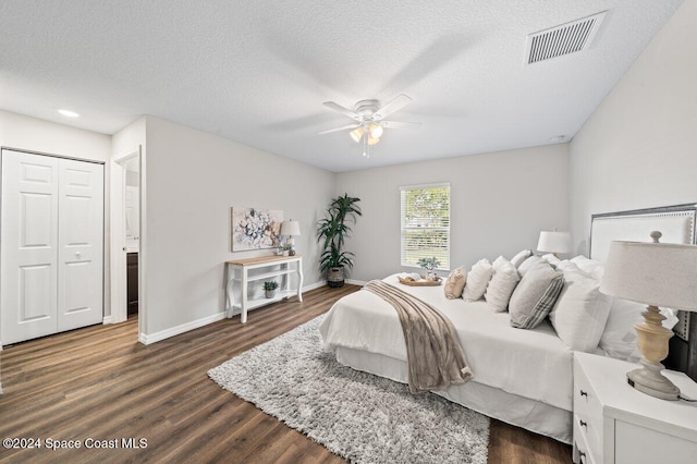 bedroom with dark hardwood / wood-style flooring, ceiling fan, a textured ceiling, connected bathroom, and a closet