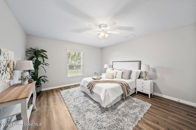 bedroom with dark hardwood / wood-style flooring, a textured ceiling, and ceiling fan